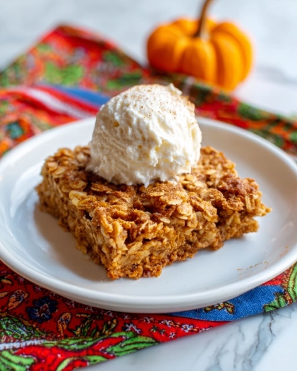 A square piece of golden-brown baked oatmeal with a slightly crispy top layer sits on a white plate. The oatmeal looks soft and textured, showing oats in a warm caramel color. On top, there is a neat dollop of white cream or yogurt, smooth and thick. The plate rests on a white marbled surface with a colorful cloth underneath, including hints of red, green, and blue in a patterned design. In the background, a small orange pumpkin sits next to a clear glass bowl filled with more white cream. photo taken with an iphone --ar 4:5 --v 7