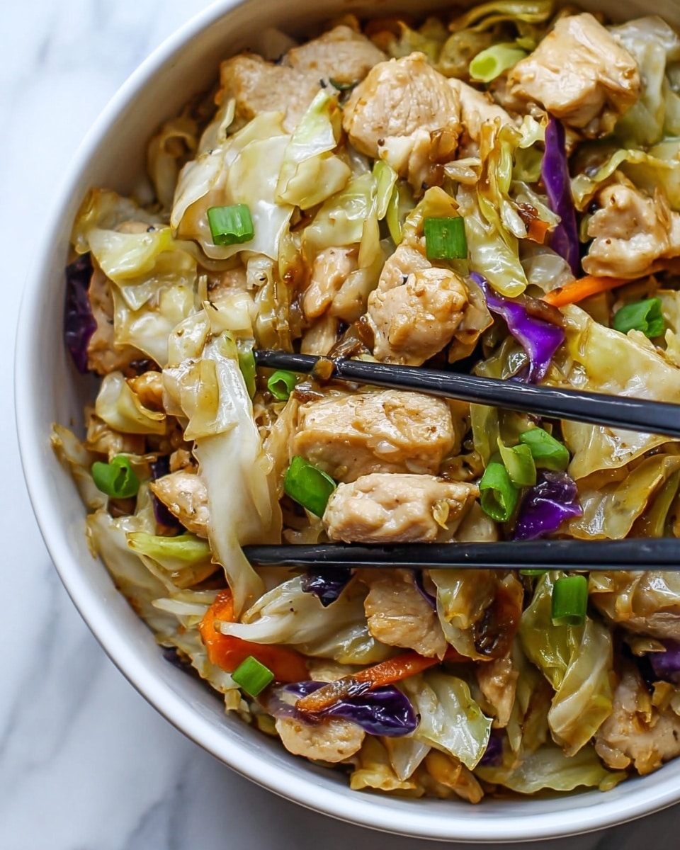 The image shows a close-up of a bowl filled with a stir-fry dish made of small chunks of cooked chicken mixed with pieces of cabbage, finely chopped green onions, and bits of purple onion and carrot. The chicken pieces are pale brown with a slightly crispy texture, while the cabbage is light green and translucent. The vegetables add bright pops of green, purple, and orange throughout. Black chopsticks are holding up some pieces from the right side. The bowl is white and sits on a white marbled surface. Photo taken with an iphone --ar 4:5 --v 7