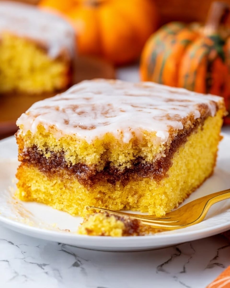 A square piece of yellow cake with a moist texture is shown on a white plate resting on a white marbled surface. The cake has two main layers: a bottom and top layer of soft yellow cake, and a thick middle layer filled with a dark brown cinnamon-like filling. The top of the cake is covered with a light, glossy white icing that looks slightly uneven and cracked. In the background, there is a small pumpkin slightly out of focus. A fork with a white plate edge is near the cake, with a small piece of the cake on it. Photo taken with an iphone --ar 4:5 --v 7